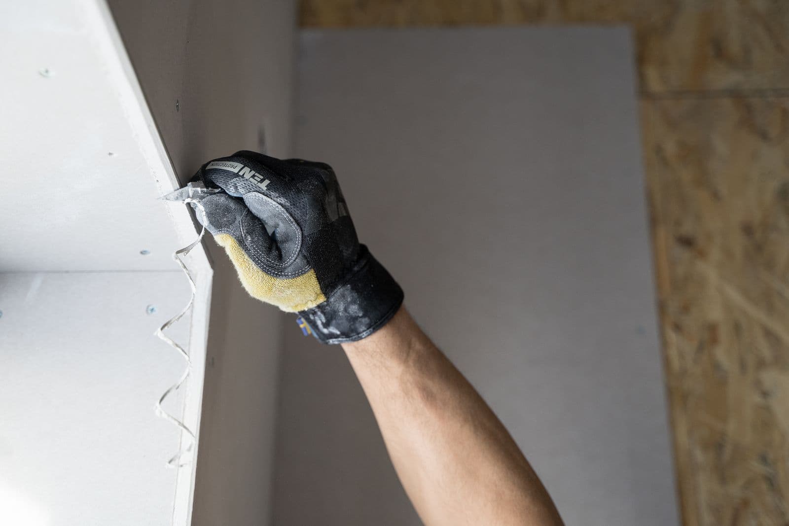 Gloved hand finishing new drywall